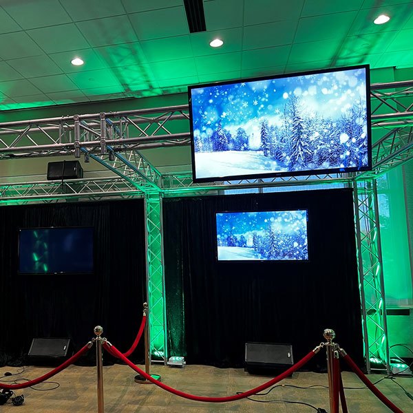 A room in Dallas, TX, featuring green lights and a large monitor displaying content