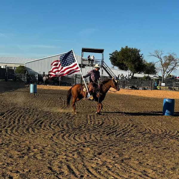 Trick roper carrying American flag during a show